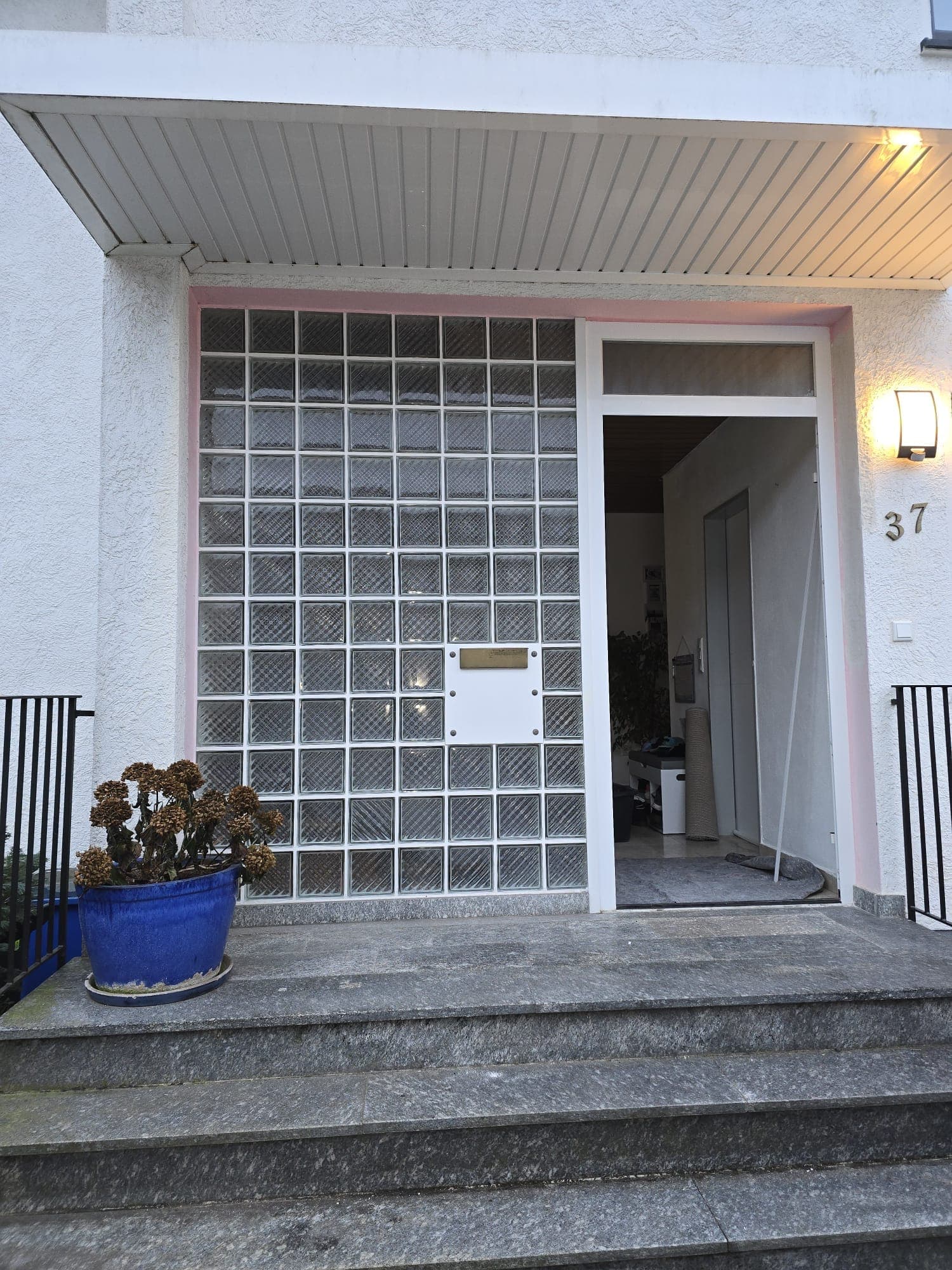 Hauseingang vor der Sanierung: Glasbausteinwand und alte Eingangstür